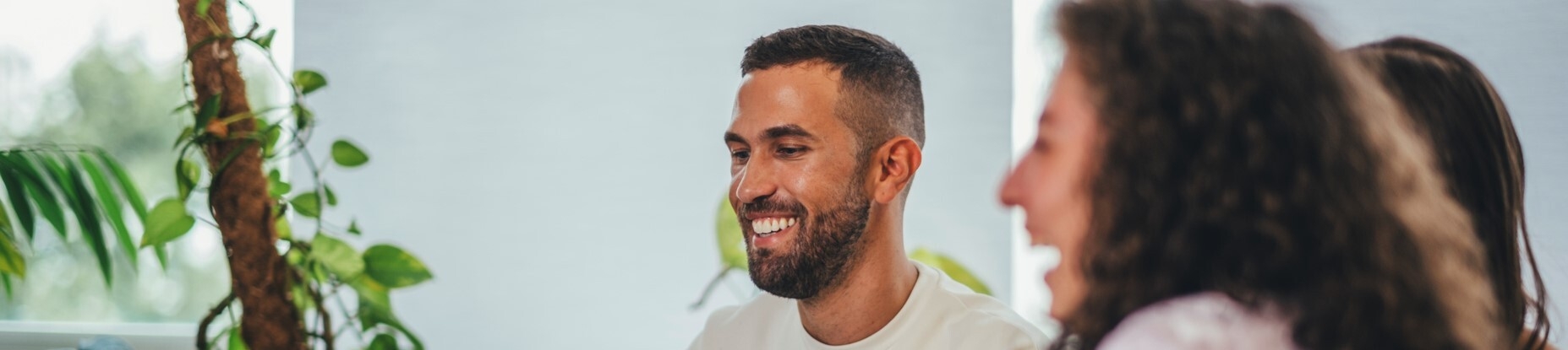 Drei Mitarbeitende der Frankfurter Buchmesse sitzen an ihren Arbeitsplätzen und unterhalten sich.