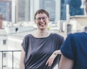 Zwei Personen unterhalten sich lachend miteinander auf dem Balkon des Haus des Buches.